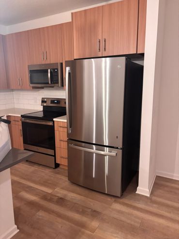 Modern kitchen with stainless steel appliances and wooden cabinets.