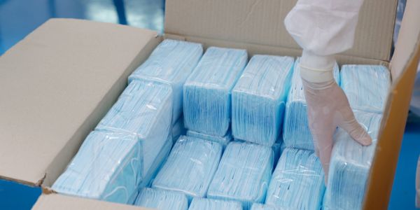 Person putting face masks in a box