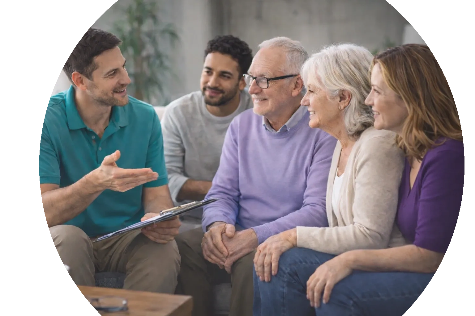 A man explains something to a group of four people, including elderly individuals, in a friendly setting.