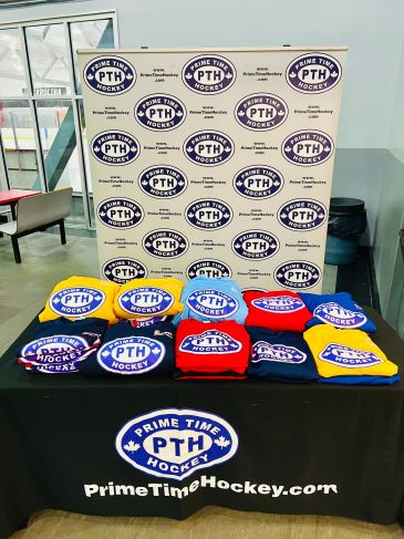 Prime Time Hockey hoodies in multiple colors displayed at a table.