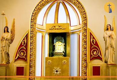 Altar religioso con figuras de ángeles y decoración dorada.