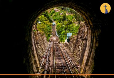 Vista desde un túnel hacia un funicular en una montaña.