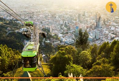 Teleférico verde sobre una ciudad al atardecer.