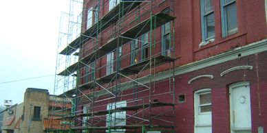 Brick building face with historic windows and scaffold 