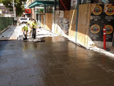 Jackson Street Seattle sidewalk replacement workers applying waterproofing membrane