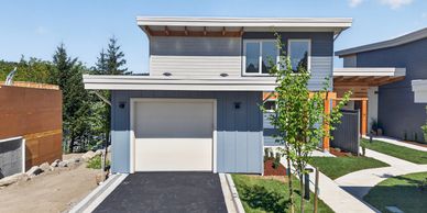 Modern two-story house with a garage and neat landscaping.