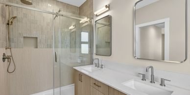 Modern bathroom with glass shower and double sink vanity.