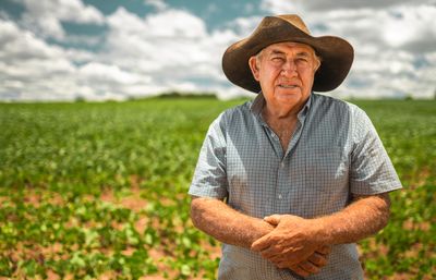 farmer in field, holding his hands, suffering from parkinson's disease