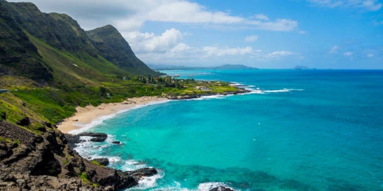 Scenic coastal view with mountains and turquoise ocean.