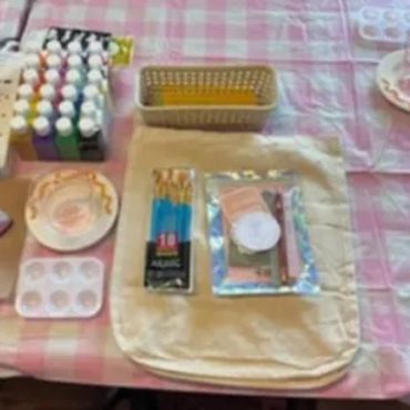 Art supplies including paint, brushes, and palettes arranged on a table.