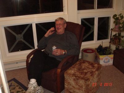a man sitting in a chair with a drink in his hand