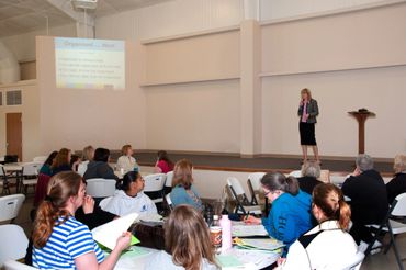 a woman giving a presentation to a group of people