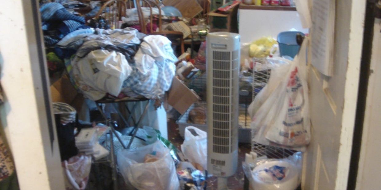a room filled with lots of clutter and a fan