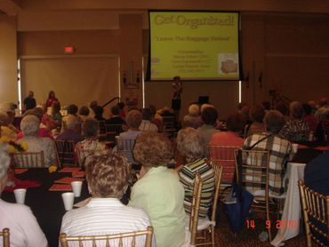a group of people sitting in chairs in front of a projector screen