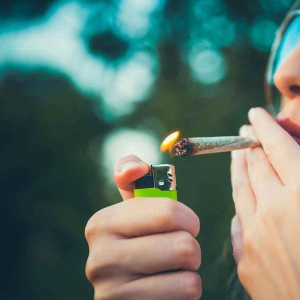 Person lighting a joint with a lighter.