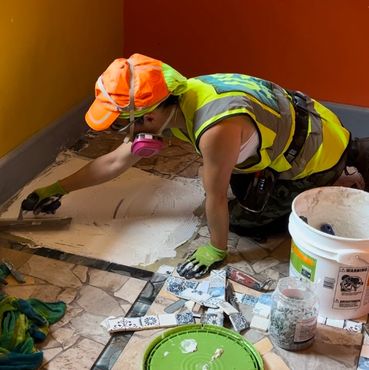 A woman installs flooring.