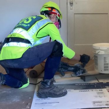 Woman sawing wood floor planks.