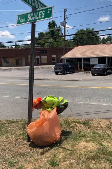 Worker cleaning near Scales Street sign.