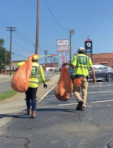 A man and woman pick up trash together.
