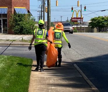 Two ladies pick up road trash for AAH.
