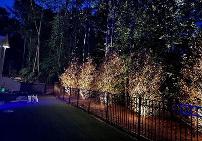 Up-lighting installation on privacy hedges by iron fence with LED outdoor lighting in Georgia by SLS