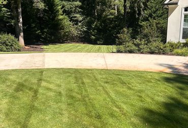 Freshly mowed lawn with clean edging and landscape beds at a residential property in Auburn, GA