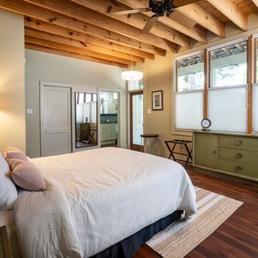 The primary bedroom en suite was added onto the original home ... those beams are spectacular!