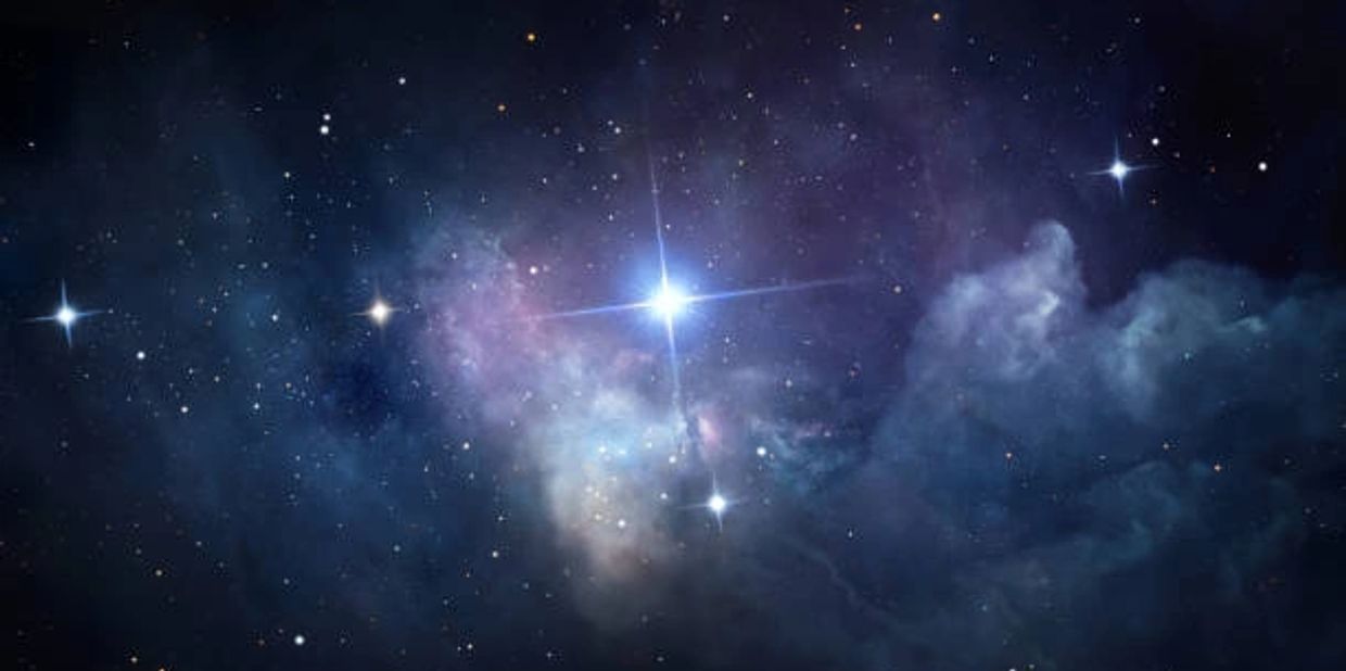 Bright stars shine through a cosmic nebula in deep space.