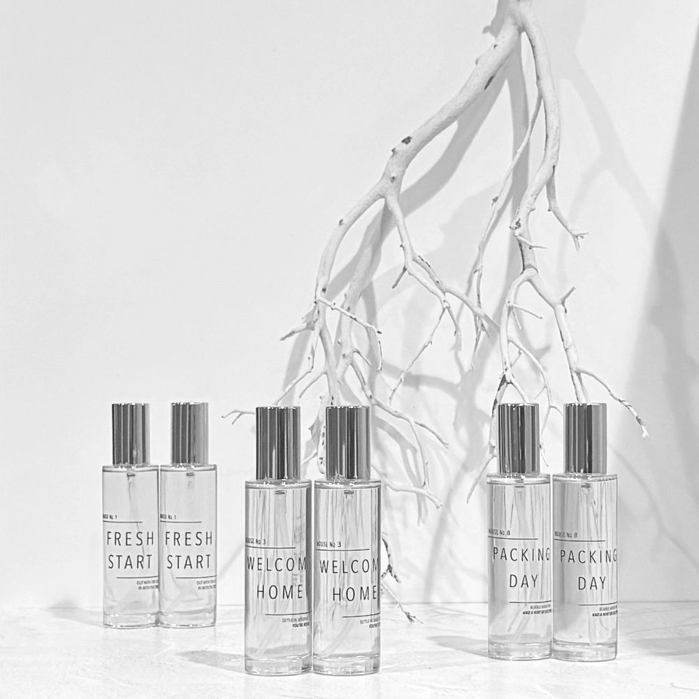 Row of room spray bottles with a driftwood twig