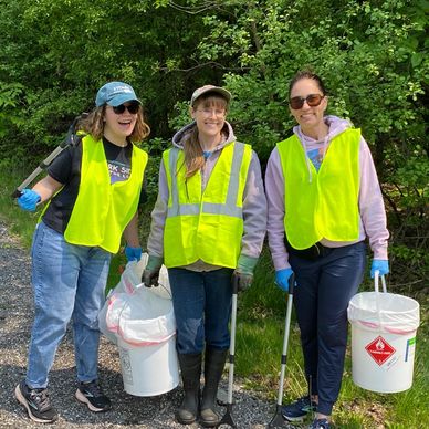 Three female smiling volunteers during a cleanup campaign