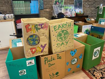 A photo of Cardboard boxes stacked up in a pyramid shape, each decorated with earth friendly designs