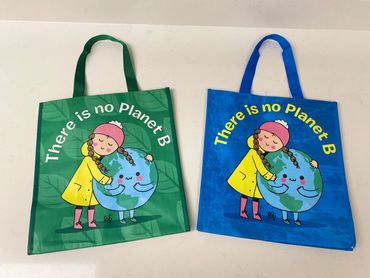 the fronts of Clean Up - Give Back's green and blue cute reusable tote bags side by side