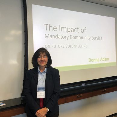 Woman giving a presentation on The Impact of Mandatory Community Service
