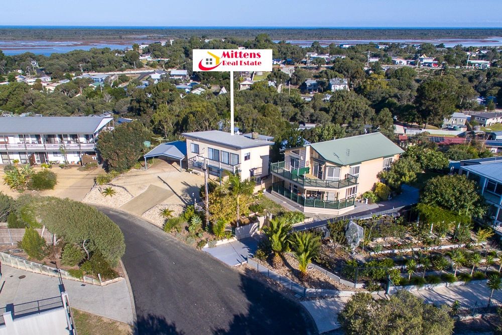 Aerial view of a residential area with a house for sale by Mittens Real Estate.