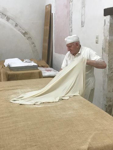 an elderly man cleaning blankets