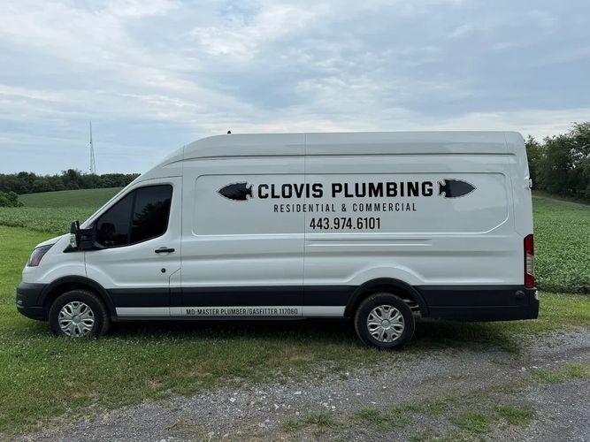 White plumbing service van with company name and contact number on the side.