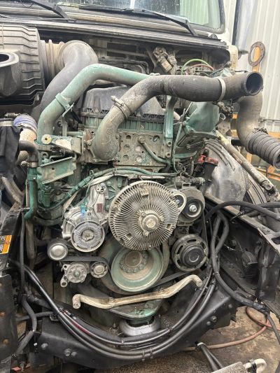 Close-up of a truck engine showing belts, pulleys, and hoses.
