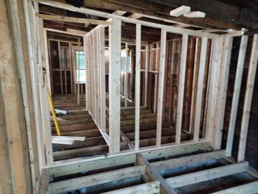 Interior of a building under construction with exposed wooden framing.