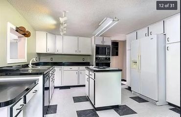 Bright kitchen with black and white decor and central island.