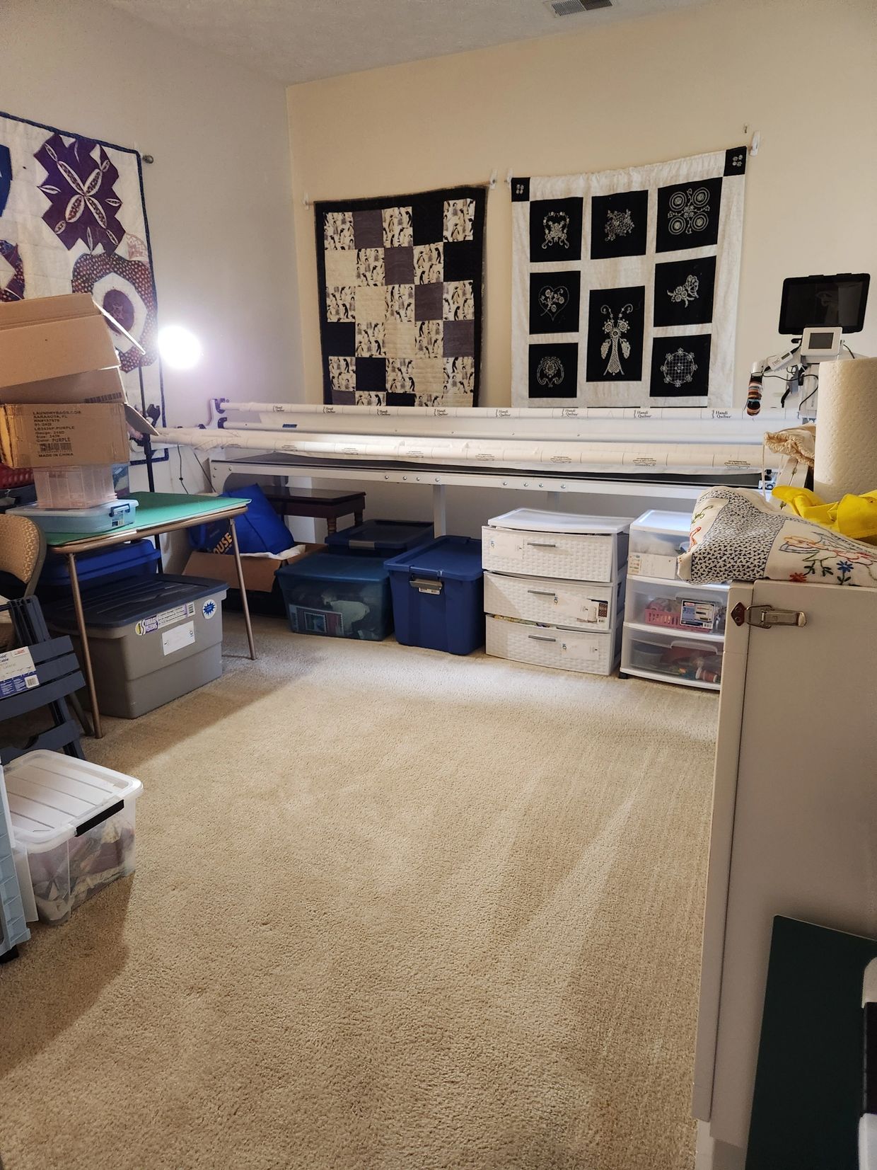 A craft room with organized storage bins and quilting supplies.