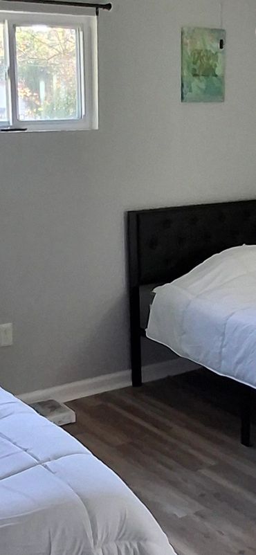 Shared bedroom with TV, 2 twin metal frame beds, 2 linen sets per bed. Separate storage space.