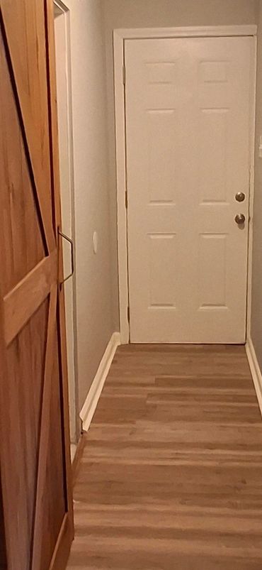 Hallway leading to the side door and laundry room. Security cameras in place.