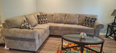 Relaxing living space featuring a sectional couch, coffee table, and soft area rug. Set up to 8