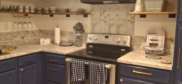 Farmhouse-style kitchen with open shelves, modern stove, and spacious countertops.