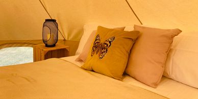 Cosy double bed in bell tent with luxury linen