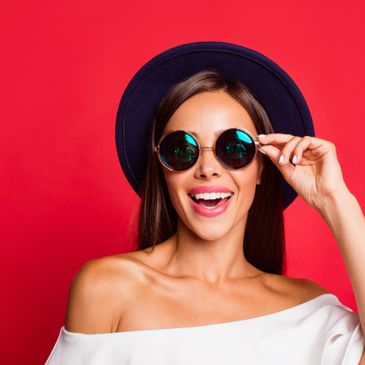 woman smiling wearing designer framed sunglasses
