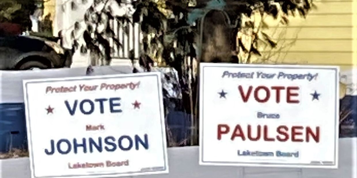 Two political campaign signs urging to vote for candidates Johnson and Paulsen.