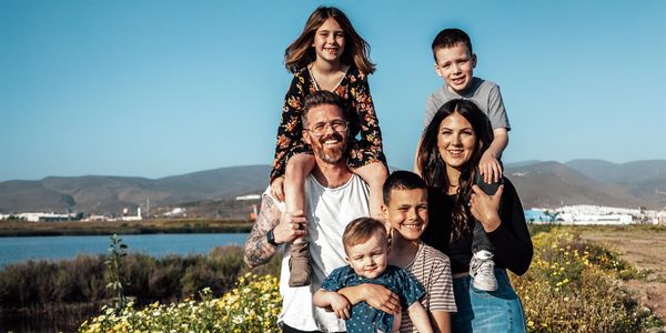 Family of six posing and smiling for photo