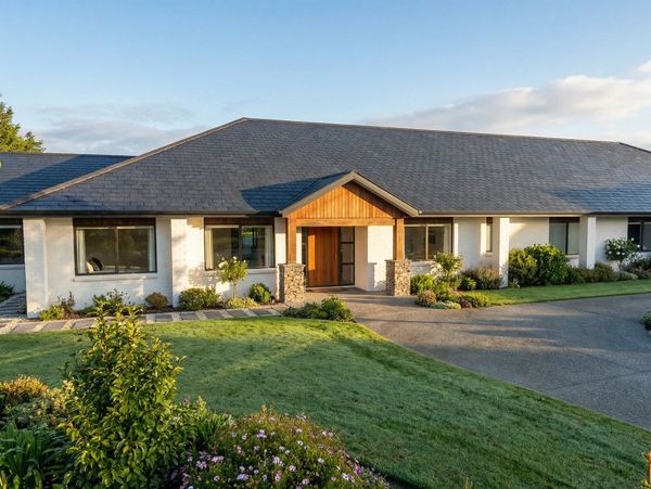 Modern single-story house with a well-maintained lawn and garden.