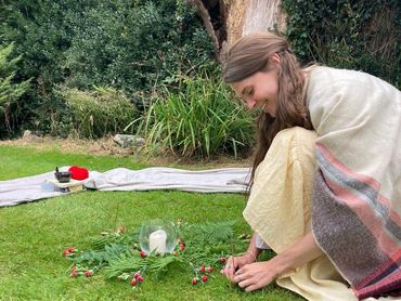 A Bath Doula sets up the centrepiece for a Women's Circle in Bristol outside on the grass